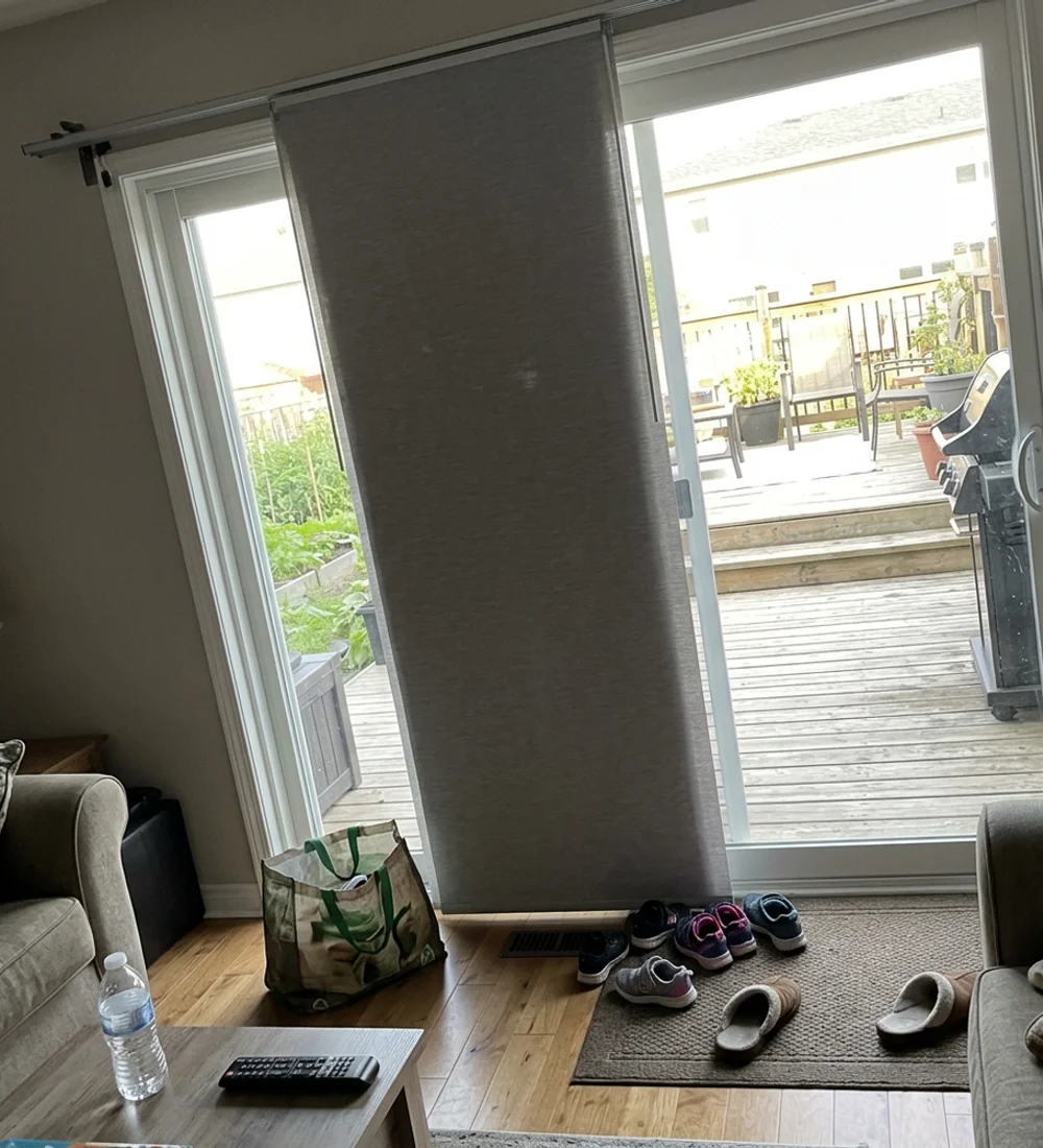 Fabric panel track shade on a wide sliding patio door in an Ottawa family room