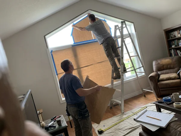 Measurer laser templating a trapezoid gable window in a Stittsville great room